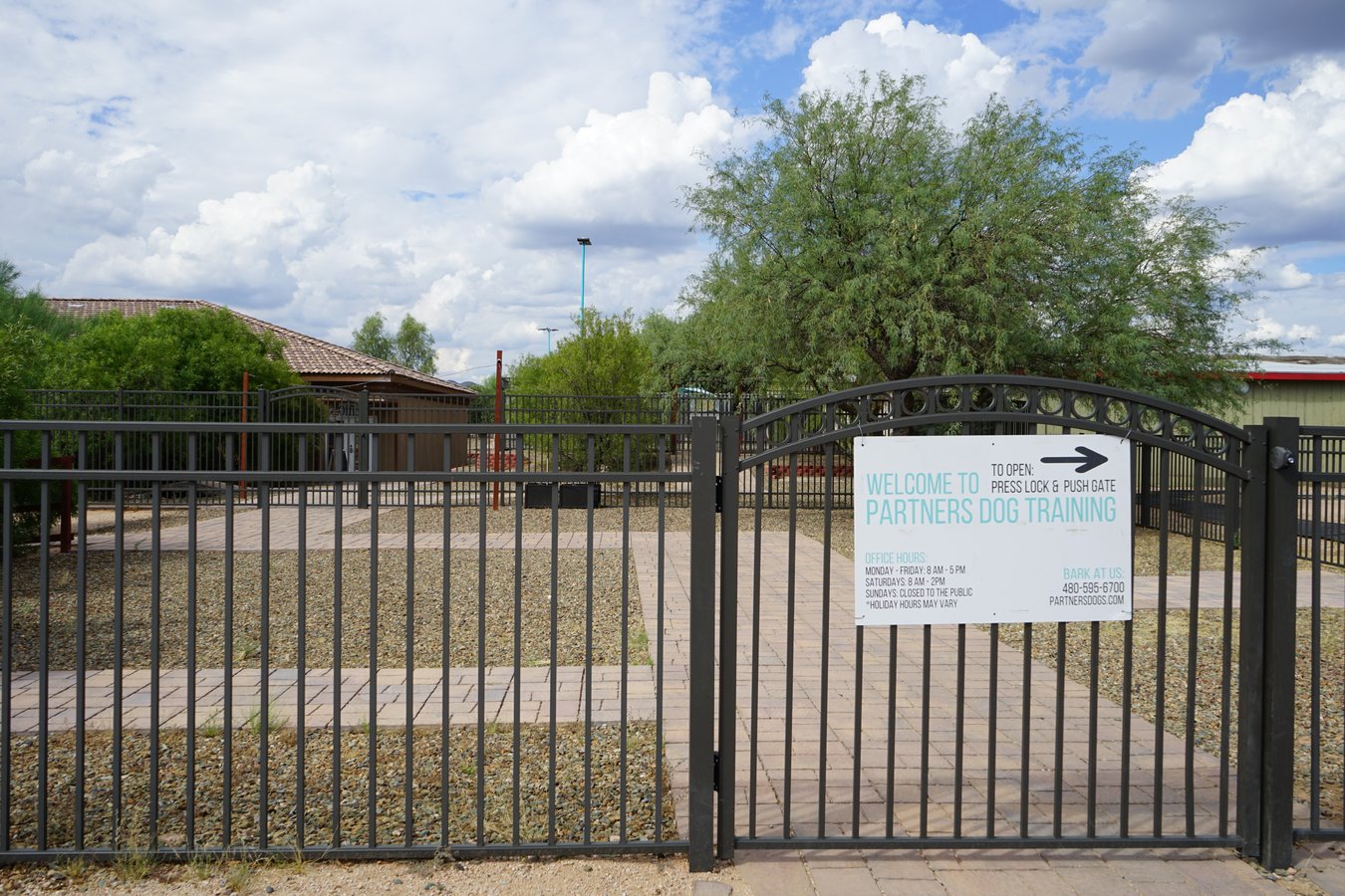 The welcome gate at the Partners Dog Training facility marks the entrance to the campus.
