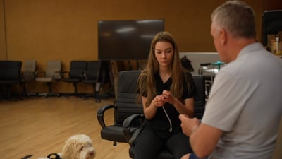 Partners Dogs trainer coaching a client one-on-one while her doodle rests nearby